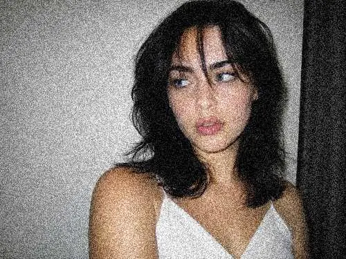 A flash portrait with visible high-ISO grain before denoising.