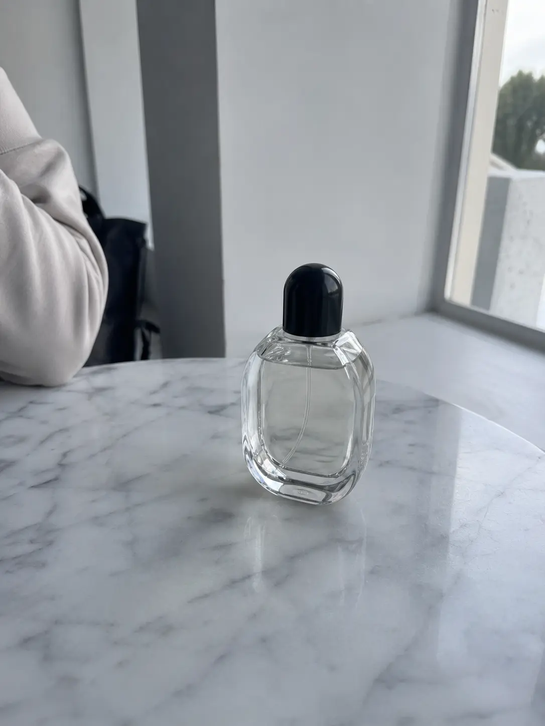 A perfume product photo before a prompt-based image edit.