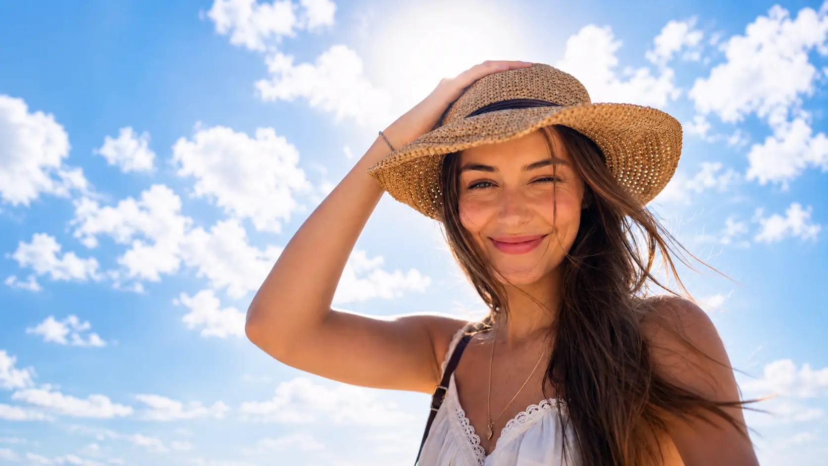 A sunny beach portrait before repair, with the subject squinting.