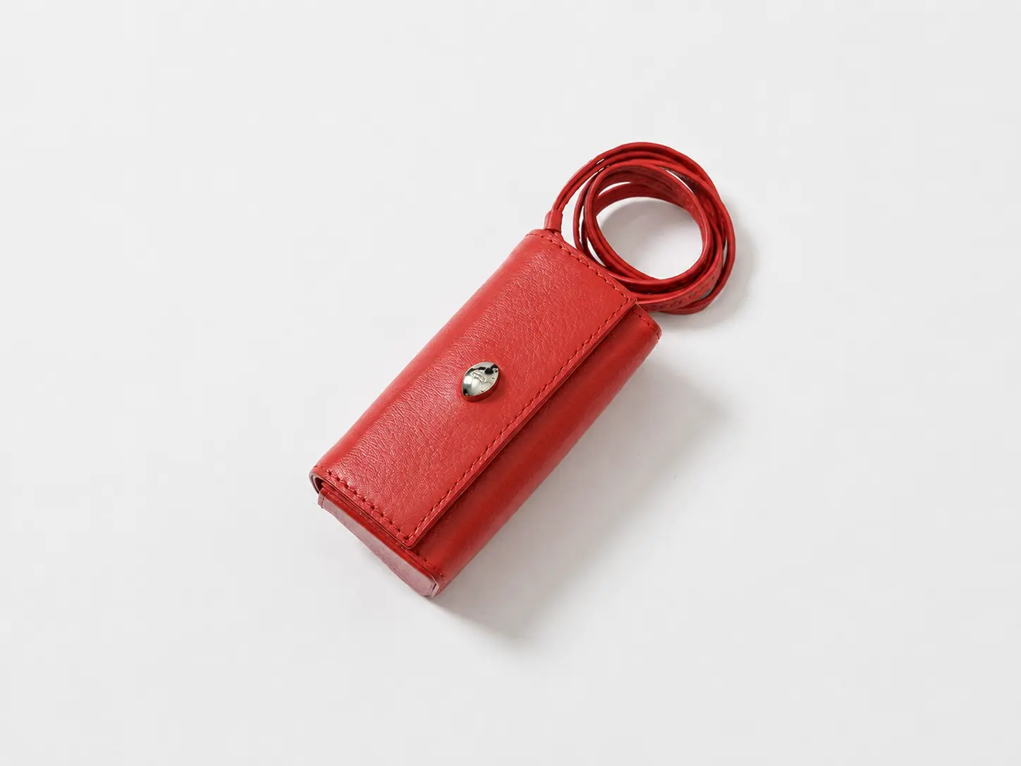 Red leather accessory with a soft AI-generated contact shadow.