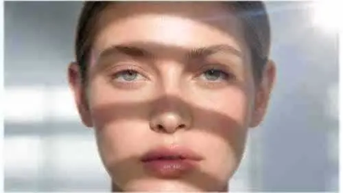 A softly focused portrait of a woman with window light across her face.