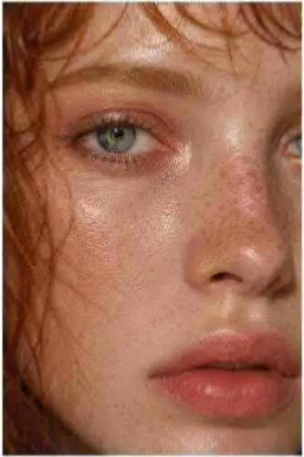 A softly focused close portrait of a red-haired woman.