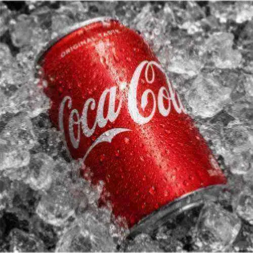 A softly focused red soda can on ice before clarity improvement.