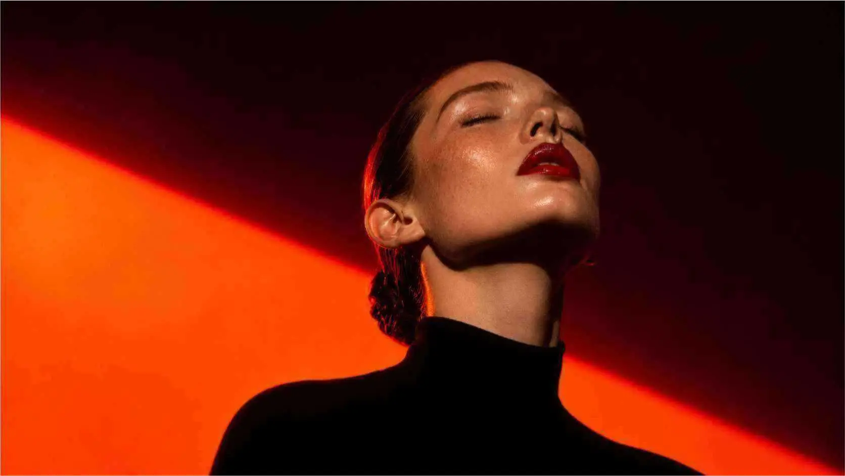 A dramatic portrait in red light before AI image enhancement.